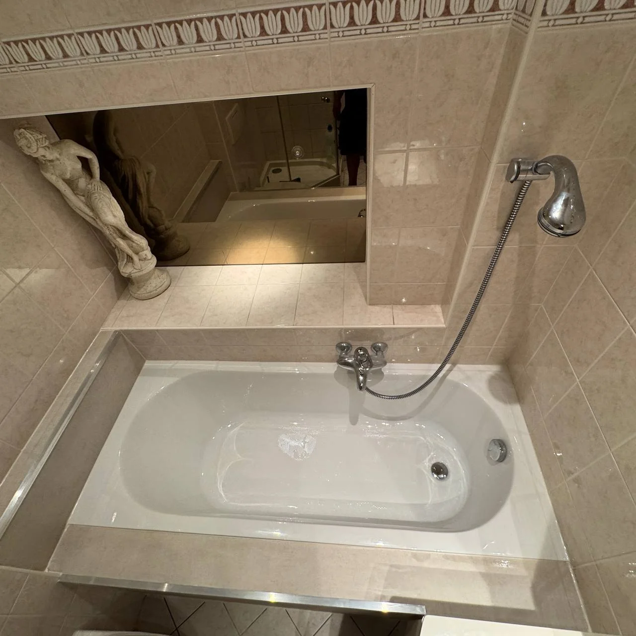 Nieuw bad met kraan en afgewerkte tegeldetails in de bestaande badkamer